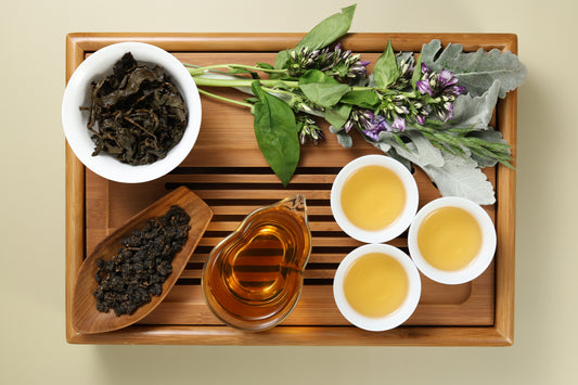 Detailed photo of Alishan High Mountain Oolong on a Bamboo Tea Tray with Dry, Wet and Brewed Alishan High Mountain Oolong from Taiwan featured prominently.