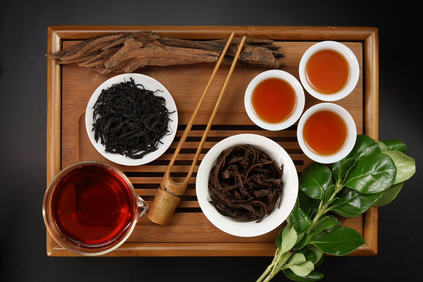 Detailed photo of Assam Aged Black Tea on a Bamboo Tea Tray with Dry, Wet and Brewed Aged Assam Black Tea from Taiwan featured prominently.
