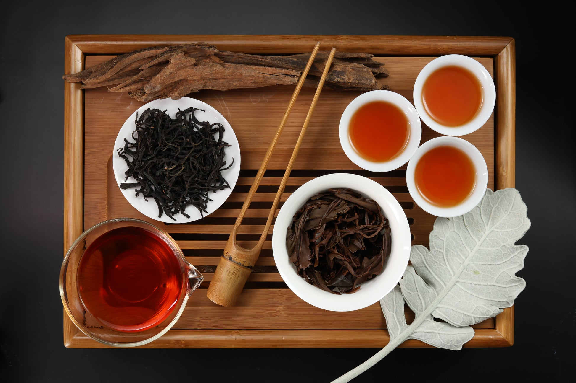 Detailed photo of Indigenous Taiwan Black Tea on a Bamboo Tea Tray with Dry, Wet and Brewed Indigenous Taiwan Black Tea from Taiwan featured prominently.