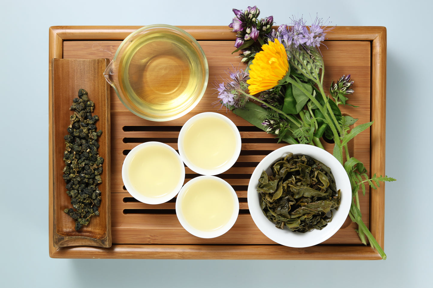 Detailed photo of Jin Xuan aka Milky Oolong on a Bamboo Tea Tray with Dry, Wet and Brewed Jin Xuan aka Milky Oolong from Taiwan featured prominently.