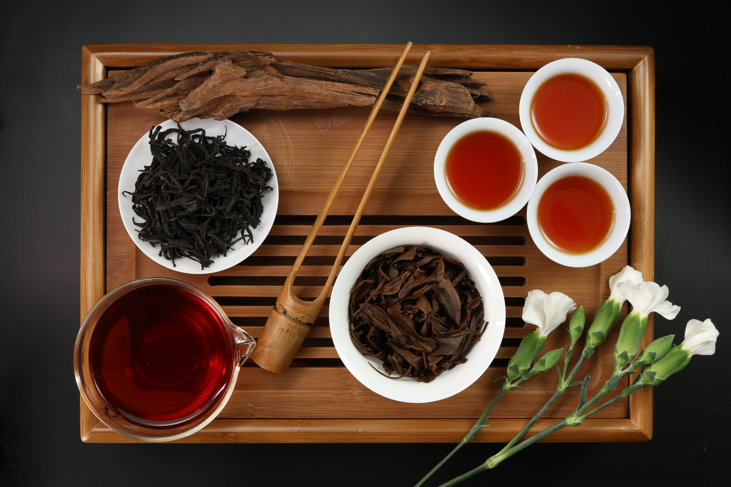 Detailed photo of Red Rhyme 21 Black Tea on a Bamboo Tea Tray with Dry, Wet and Brewed Red Rhyme 21 Black Tea from Taiwan featured prominently.