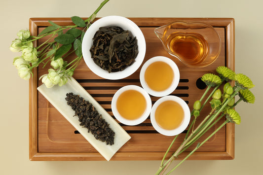 Detailed photo of Shan Lin Xi High Mountain Oolong on a Bamboo Tea Tray with Dry, Wet and Brewed Shan Lin Xi High Mountain Oolong from Taiwan featured prominently.